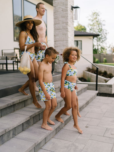 Family on Steps in Lifestyle photo wearing Navalora Amalfi Coast Lemon Matching Swimsuits Boy's Bathing Suit 
