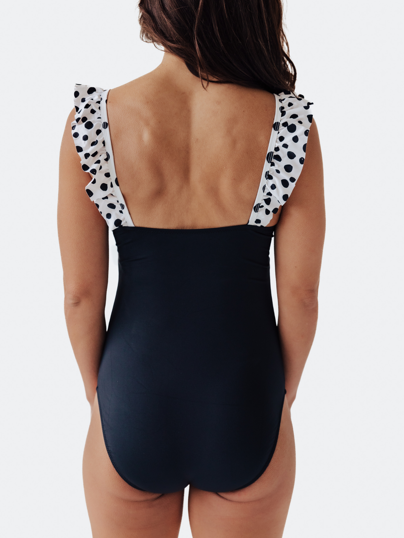 Full-coverage back view of our one-piece swimsuit with playful polka dots. Double-lined for comfort and support. Shop the "Dalmatians on Vacation" collection at navalora.com.