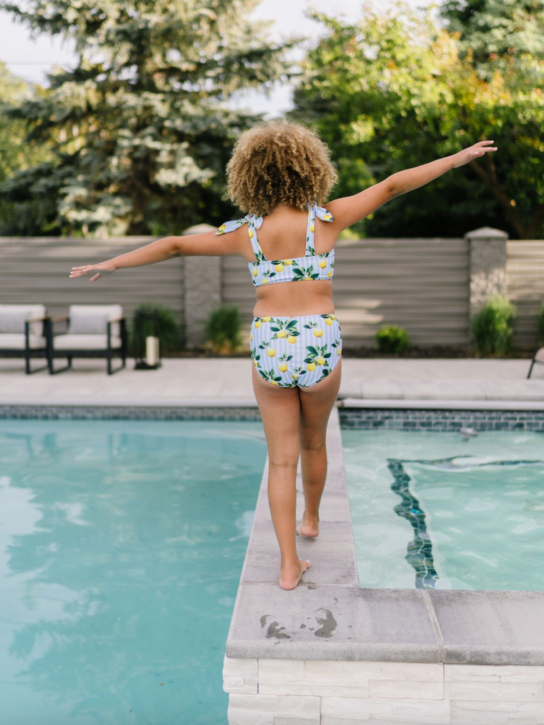Navalora Swim Girl's Amalfi Coast Inspired Lemon Tie Top Bikini Swimsuit with Adjustable Ties, Girl Standing By the Pool, Back View