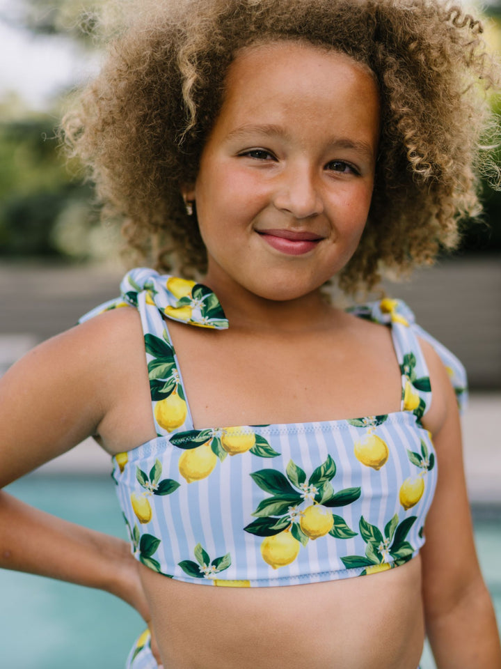 Navalora Swim Girl's Amalfi Coast Inspired Lemon Tie Top Bikini Swimsuit with Adjustable Ties, Girl Standing By the Pool, Close Up Top View